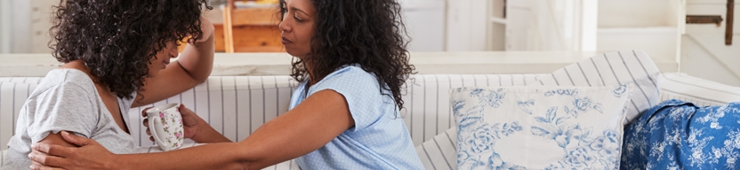 A teenager is being consoled by a parent or friend